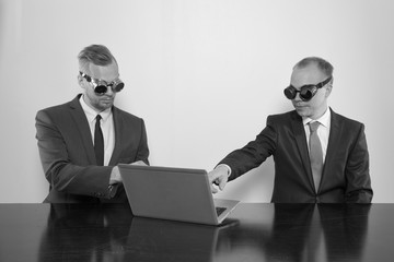 Wall Mural - Two businessman sitting at office desk