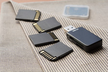 Black Memory Cards And Card Reader On Textile Background