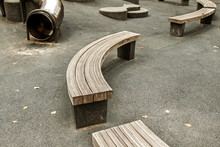 Empty Curved Wooden Benches On A Kids Playgrond.