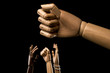 Hands manifest under a large closed fist.  About racism. Isolated on black background. With copy space text. Studio shot.