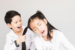 © pairhandmade - Lovely Asian couple school kids playing together, 7 and 10 years old, over gray background