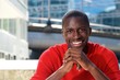 © mimagephotos - Handsome young black guy sitting outdoors and smiling