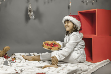 Girl wearing Santa hat and white clothes, holding a tambourine w