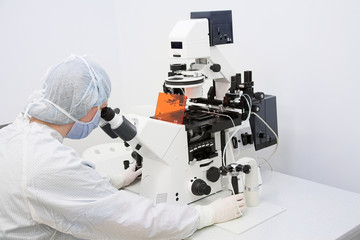 Wall Mural - Woman looking in microscope