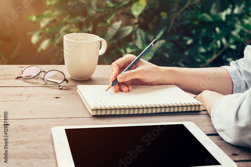 Fotomural Young business woman hand with pencil writing on notebook. Woman