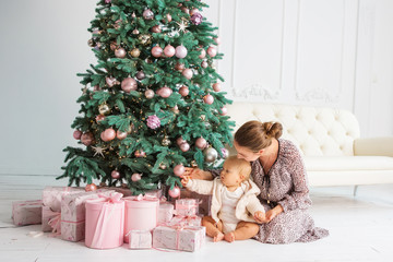 Kid and mother near new-year tree