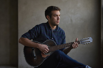 Playing on guitar. Shot of a young talent musician practicing on his electric guitar.