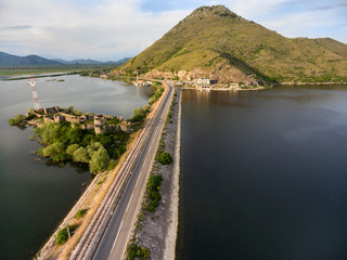 Top view at the dam with railroad and highway passing through the Skadar lake and near Lesendro fortress. Route from Podgorica to Adriatic coast. Montenegro