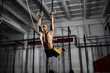 © baranq - Muscle-up exercise athletic man doing intense workout at the gym on gymnastic rings