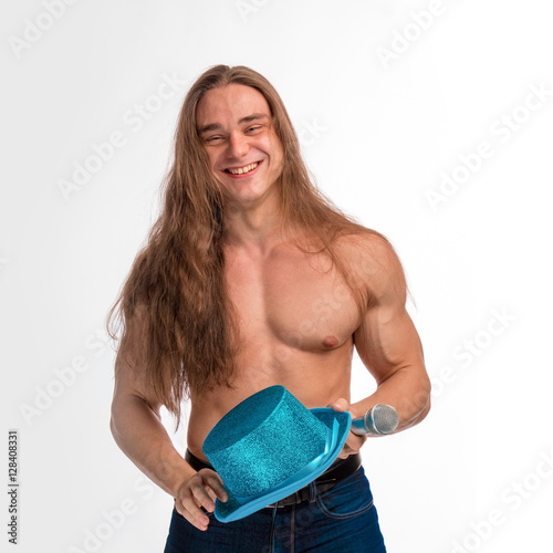 Fotografía singer bodybuilder shirtless with long hair in a blue hat with a microphone on a