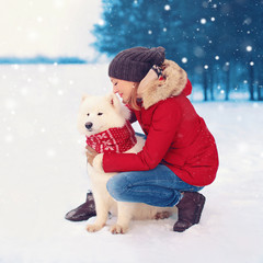 Wall Mural - Happy woman owner embracing white Samoyed dog in winter christma