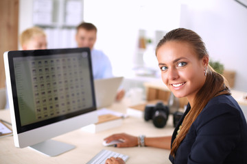 Fashion designers working in studio sitting on the desk