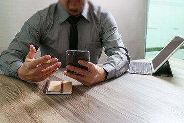 businessman using smart phone and keyboard dock digital tablet.W