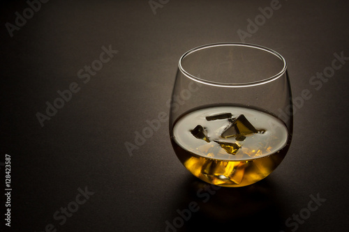 Fotografie, Obraz glass of whiskey shot against a dark background