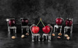 Red delicious ripe cherries on vintage small silver chairs  with cherrystones on dark background with copy space