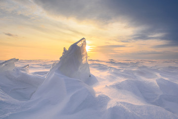 Wall Mural - boundless icy landscape during a snowstorm at sunset in winter.