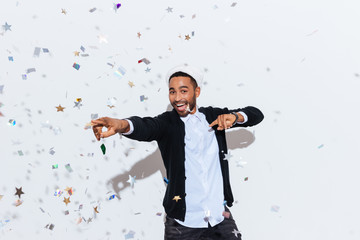 Cheerful african american young man in santa claus hat dancing