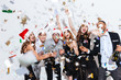 © Drobot Dean - Cheerful excited friends in santa claus hats celebrating new year