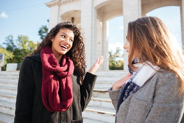 two gorgeous young women wearing scarfs communication