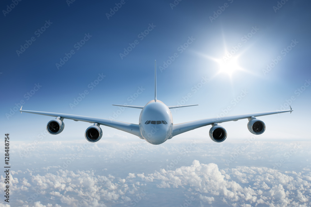 Big airplane flying above the clouds, towards the camera with the sun in blue sky - obrazy, fototapety, plakaty 