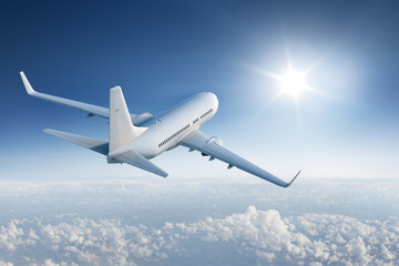airliner flying towards the sun in blue sky