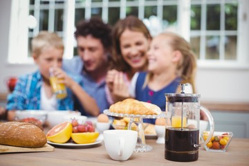 Food on table while happy family in background