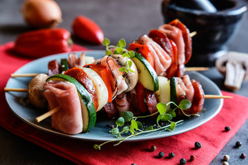 Wall Mural - Roasted skewers with sausage, bacon, ham, zucchini, onion, pepper and mushroom