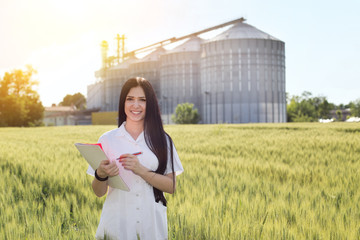 Wall Mural - Agronomist in field with silos behind