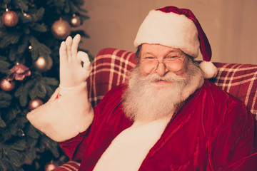 Funny Santa Claus wearing red costume showing gesture ok with fi