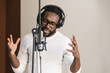 © santypan - African young man singing on musical studio.