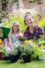 Wall Mural - Portrait of mother and daughter gardening together in garden