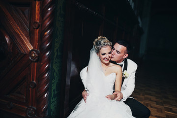 Wall Mural - Groom kisses his happy bride to the cheek