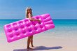 Slim blonde woman with air mattress tropic beach