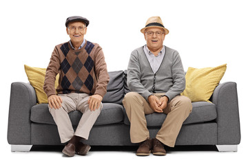 Wall Mural - Two joyful elderly men sitting on a sofa