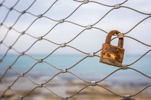 Single Rusty Love Padlock On A Fence Along The Coastline