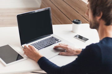 Business man using laptop computer. Male hand typing on laptop keyboard. Blank computer monitor
