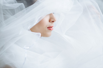 close-up red lips of a beautiful woman with white veil on her face. only lips are visible