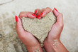 Heart shape made from sand in woman hands