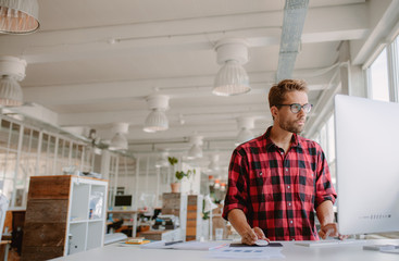 Young man working on computer in modern workplace