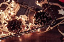 A Basket Filled With Christmas Lights And Pine Cones For Decoration On A Table. Top View