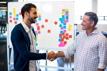 Aufkleber - Colleagues shaking hands in front of white board