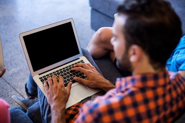Aufkleber - Man siting on sofa using laptop