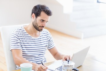 Poster - Man writing note using laptop