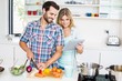 © WavebreakmediaMicro - Young couple chopping vegetable and using digital tablet