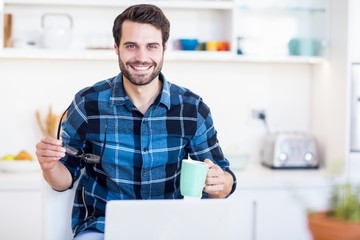 Poster - A man is holding his glasses and a mug