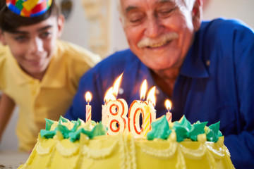 Wall Mural - Boy and Senior Man Blowing Candles On Cake Birthday Party