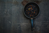 Fototapeta Zwierzęta - The failure on kitchen: burnt charred vegetables in frying pan on dark shabby background