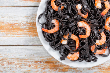 Wall Mural - delicious Cuttlefish ink pasta with prawns, top view