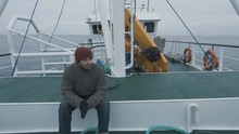 Lone Fisherman Sitting On Bench At The Commercial Ship. Shot On RED Cinema Camera In 4K (UHD). 