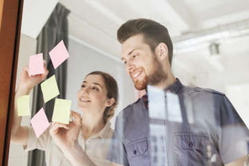 Wall Mural - happy creative team writing on stickers at office